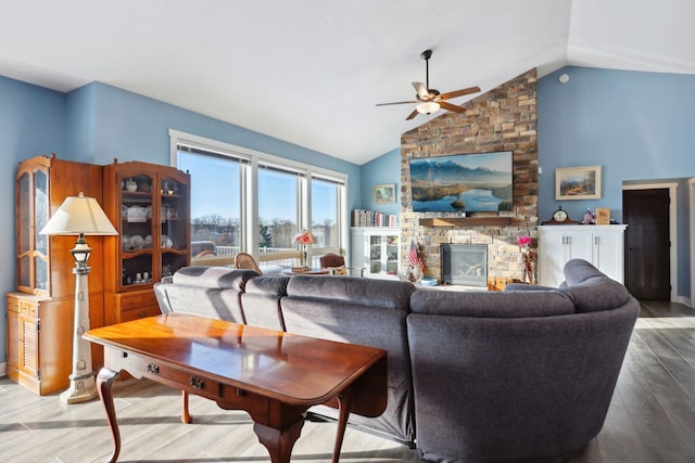 living room with a ceiling fan, a fireplace, high vaulted ceiling, and wood finished floors