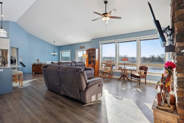 living room with plenty of natural light, dark wood finished floors, washer and dryer, and ceiling fan with notable chandelier