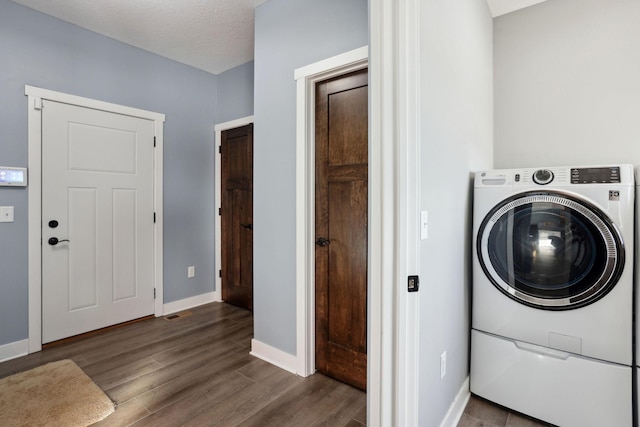 laundry room with a textured ceiling, washer / clothes dryer, dark wood finished floors, and baseboards