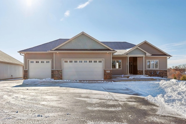 craftsman-style house featuring a garage and stone siding