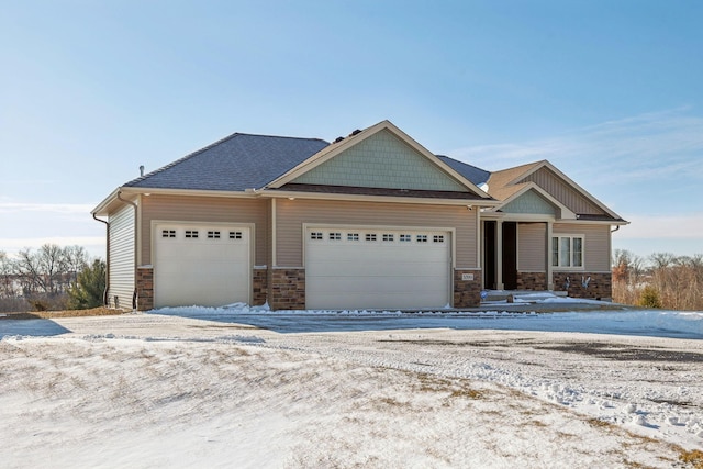 craftsman-style house with a garage and stone siding