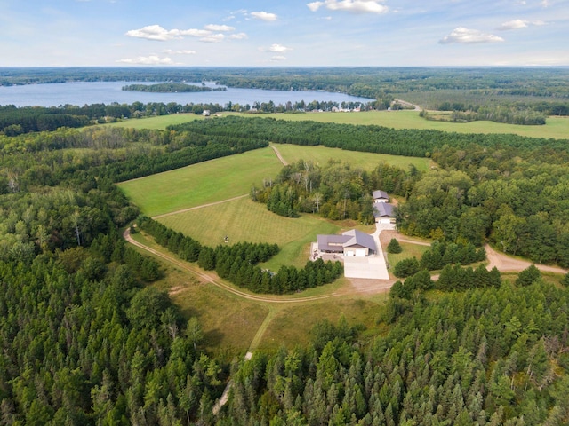 drone / aerial view with a water view, a wooded view, and a rural view