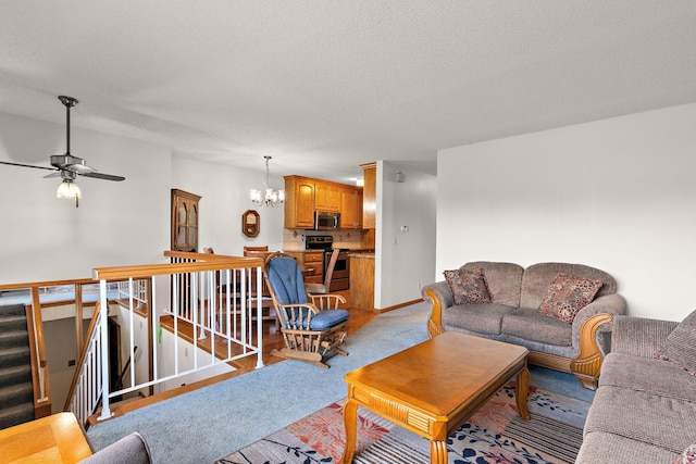 living room featuring light carpet, a textured ceiling, baseboards, and ceiling fan with notable chandelier