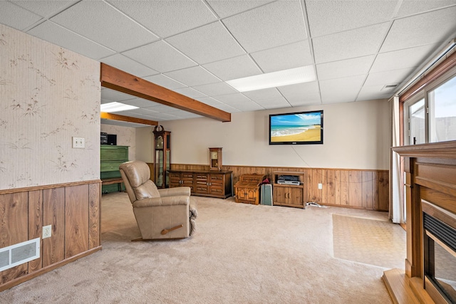 sitting room with a paneled ceiling, visible vents, and wainscoting