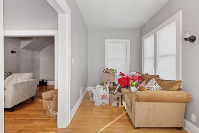 sitting room with wood finished floors, visible vents, and baseboards