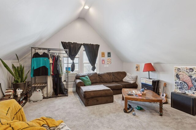 living area with light carpet, lofted ceiling, and baseboards