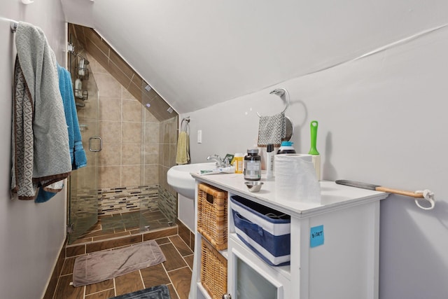 bathroom featuring a stall shower, lofted ceiling, vanity, and wood tiled floor