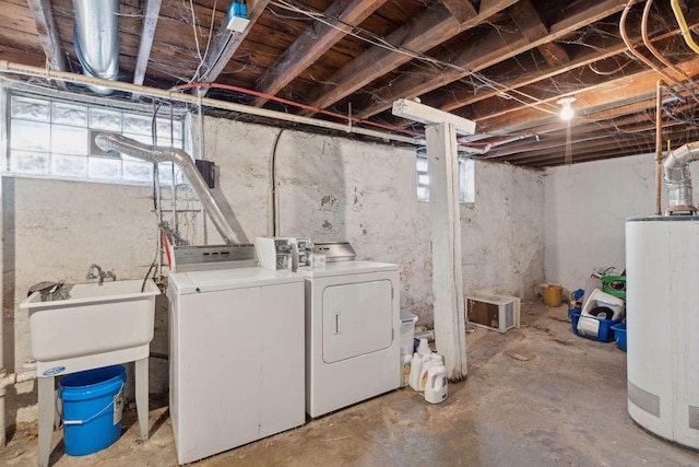 basement featuring water heater, a sink, and washer and dryer