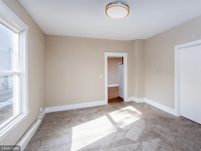 unfurnished room featuring light carpet, baseboards, and baseboard heating