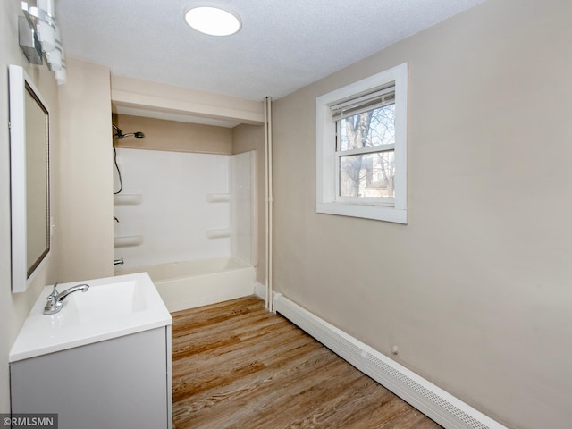 full bathroom featuring baseboard heating, a textured ceiling, shower / tub combination, wood finished floors, and baseboards