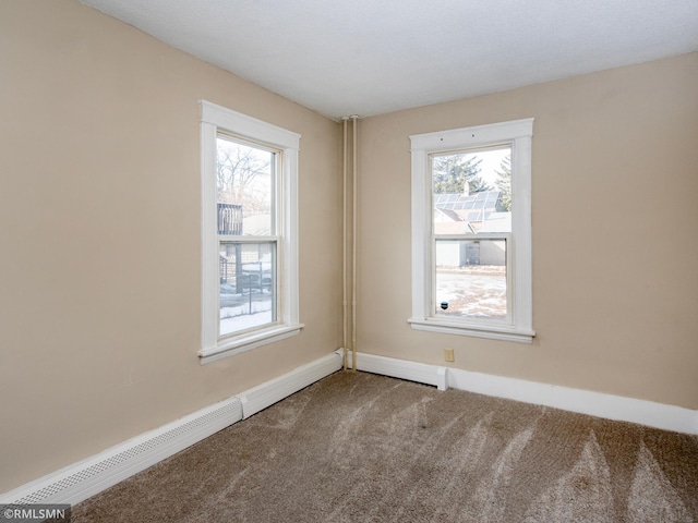 carpeted empty room with baseboard heating and baseboards