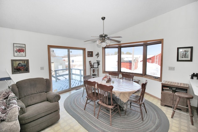 dining area with light floors, ceiling fan, baseboards, and vaulted ceiling