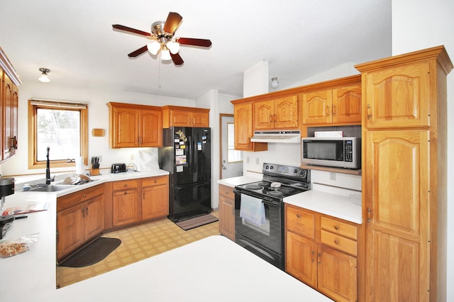 kitchen with light floors, light countertops, a sink, and black appliances