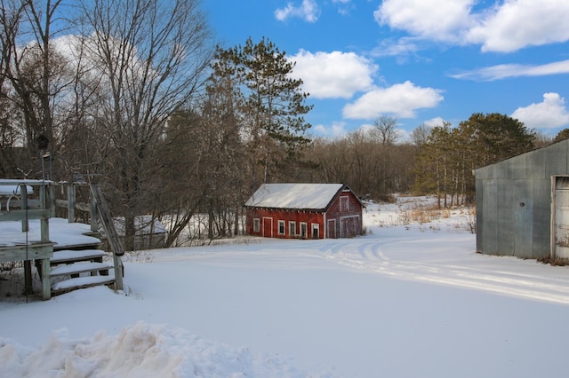 yard layered in snow featuring an outdoor structure and a barn