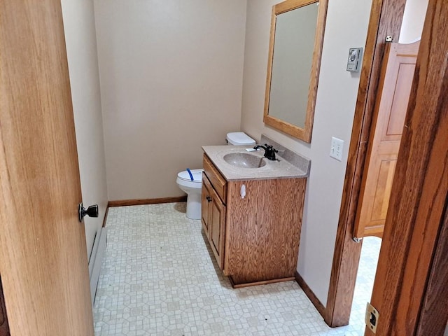 bathroom with baseboards, vanity, toilet, and tile patterned floors