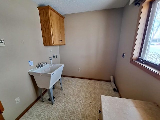 washroom featuring baseboard heating, cabinet space, and baseboards