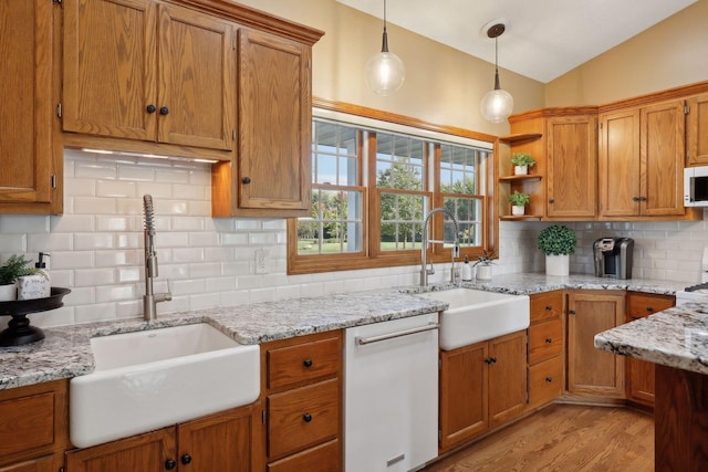 kitchen with white dishwasher, open shelves, a sink, and decorative light fixtures