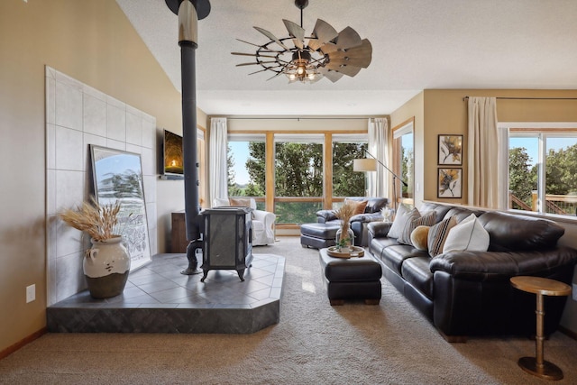 carpeted living area with a wood stove, vaulted ceiling, and a textured ceiling