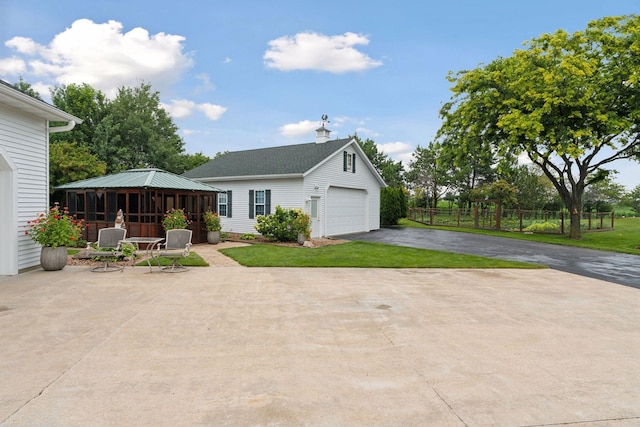 view of front facade with a garage, a gazebo, fence, an outdoor structure, and a front yard