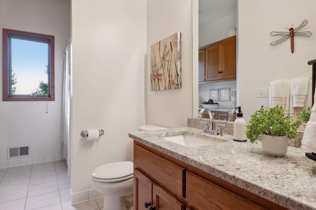 bathroom with visible vents, toilet, vanity, baseboards, and tile patterned floors