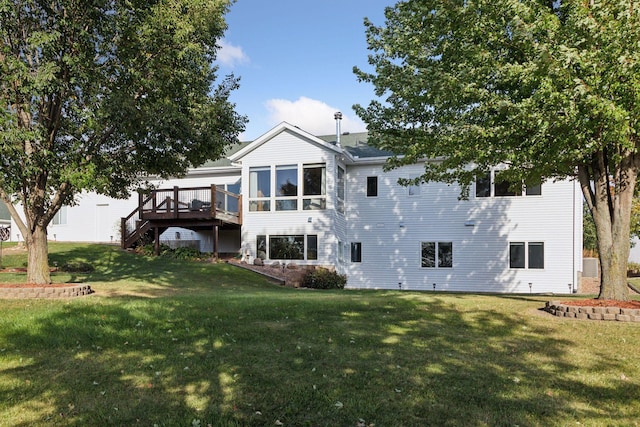 rear view of property featuring a deck, a lawn, and stairs