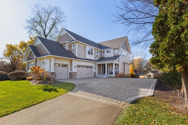 view of front facade with an attached garage, stone siding, decorative driveway, board and batten siding, and a front yard