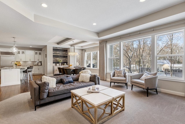 living area featuring light wood finished floors, baseboards, beamed ceiling, a textured ceiling, and recessed lighting