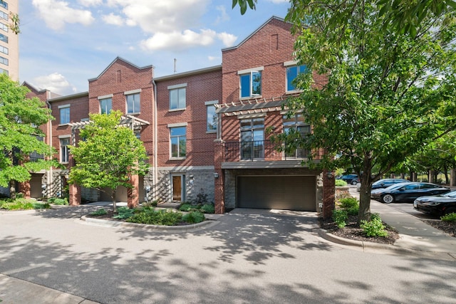 view of front of home featuring a garage, brick siding, and driveway