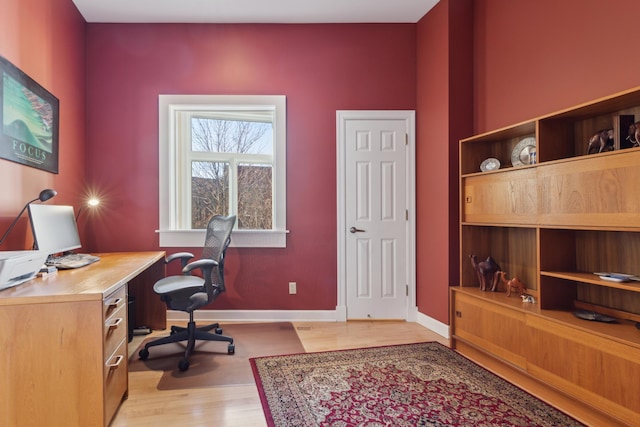 office area with light wood-style floors and baseboards