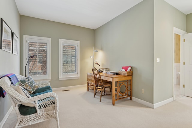 home office with baseboards, visible vents, and light colored carpet