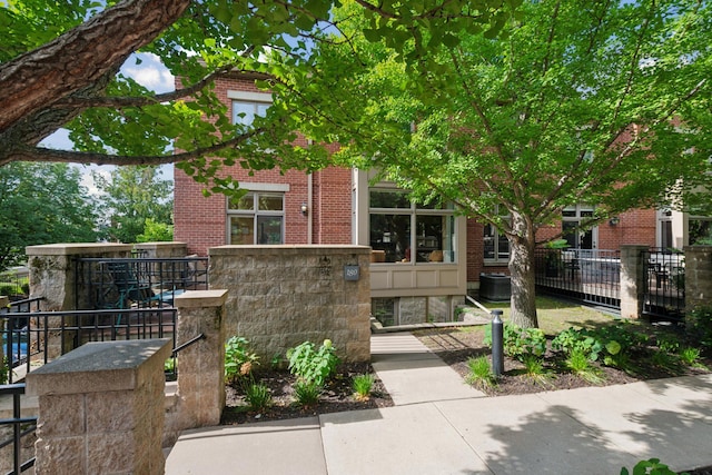 view of front facade with brick siding and fence