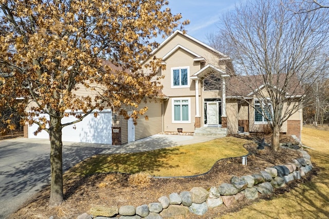 view of front facade featuring brick siding, driveway, a front yard, and a garage