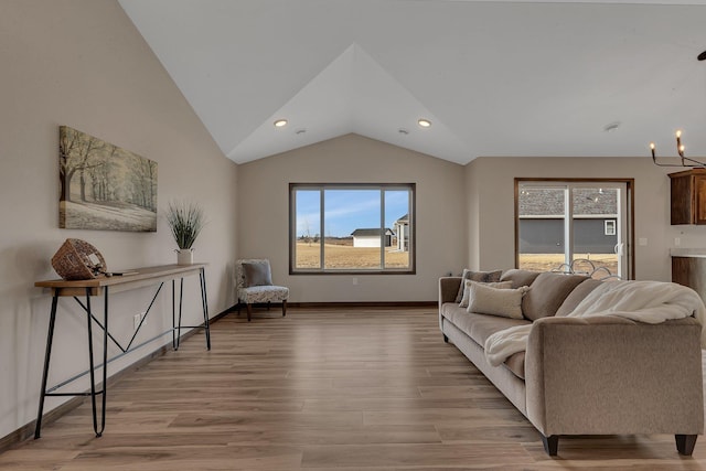 living area featuring recessed lighting, baseboards, lofted ceiling, and light wood-style floors