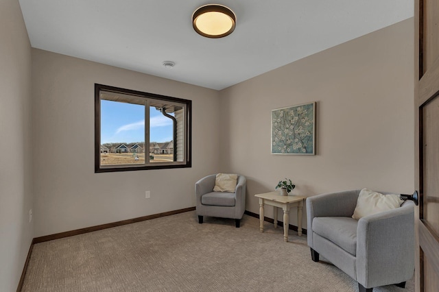 living area featuring baseboards and light colored carpet