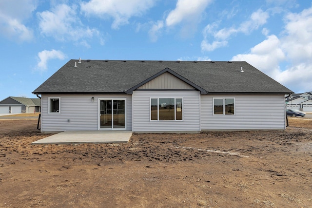 rear view of house featuring a shingled roof and a patio area