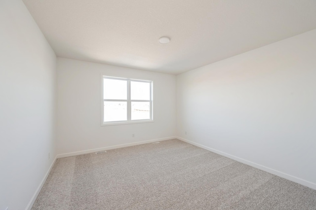 unfurnished room with baseboards and carpet flooring