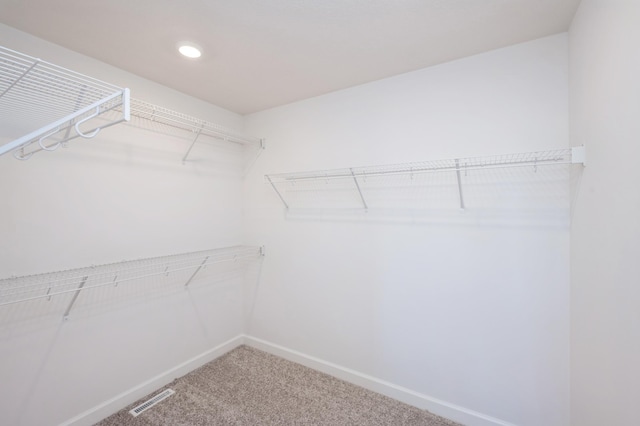 walk in closet featuring visible vents and carpet flooring