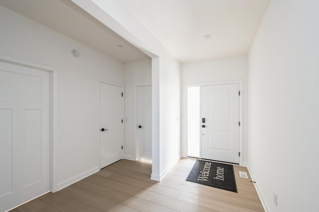 entrance foyer with light wood-style flooring and baseboards