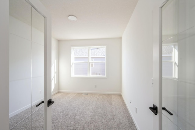 unfurnished bedroom featuring baseboards and light colored carpet