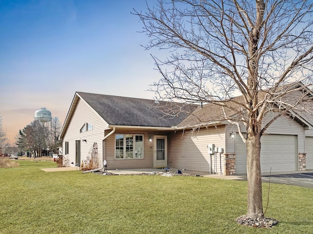 ranch-style house with a garage, driveway, a shingled roof, and a front lawn