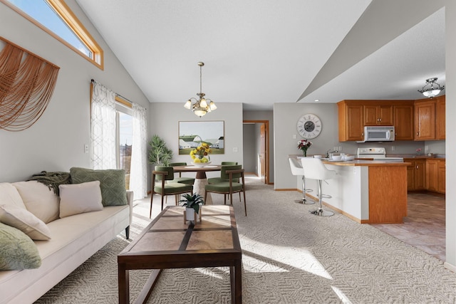 living room featuring a chandelier, light colored carpet, high vaulted ceiling, and baseboards