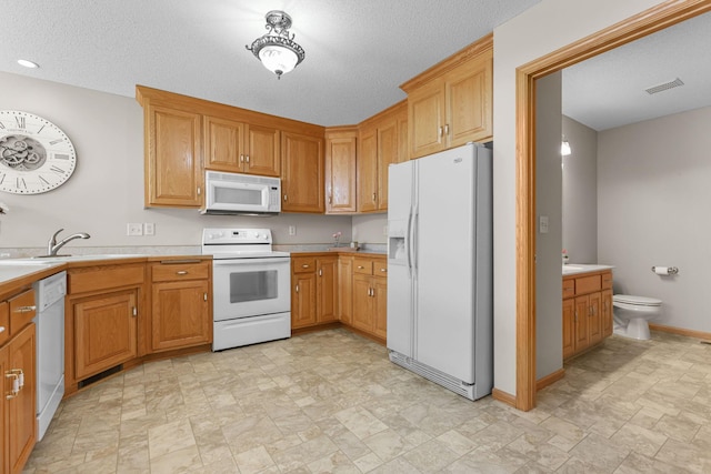 kitchen with white appliances, baseboards, visible vents, and light countertops