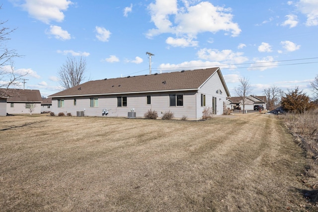 back of property with central air condition unit and a yard