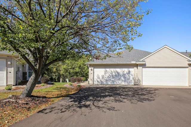 view of front of house featuring a garage and a shingled roof