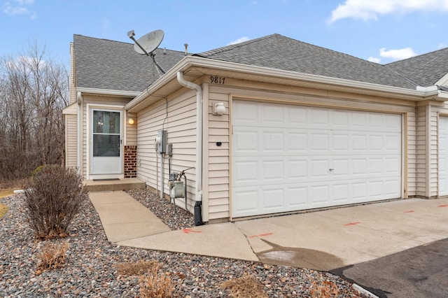 view of property exterior featuring a shingled roof, driveway, and a garage