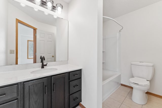 bathroom featuring tile patterned flooring, toilet, vanity, baseboards, and washtub / shower combination