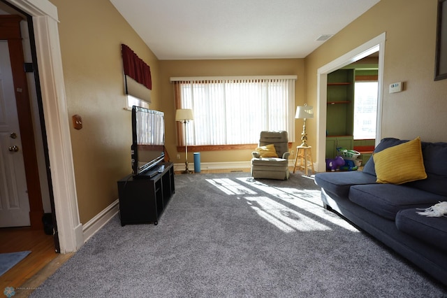 living area with carpet flooring, visible vents, and baseboards