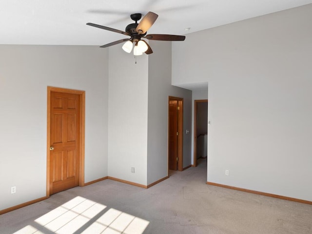 unfurnished room featuring baseboards, high vaulted ceiling, a ceiling fan, and light colored carpet