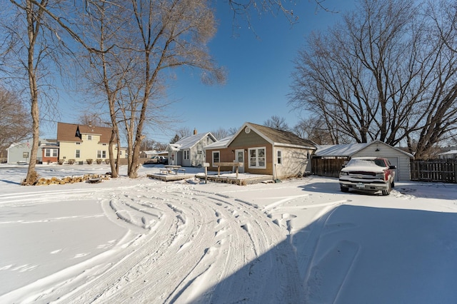 view of front of property with fence and an outbuilding