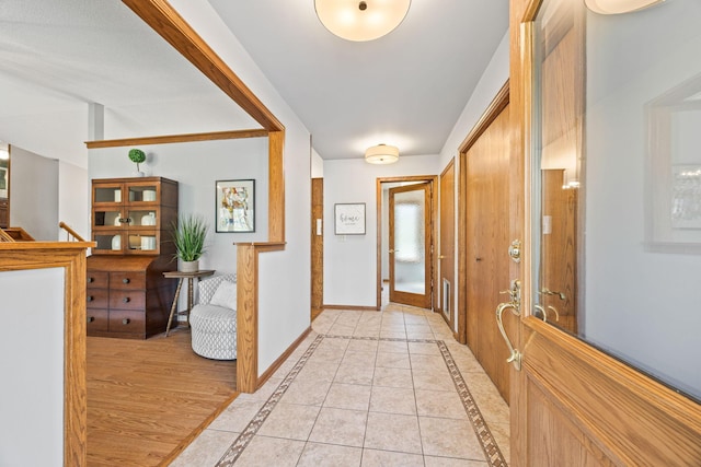 hallway featuring inlaid floor details and baseboards